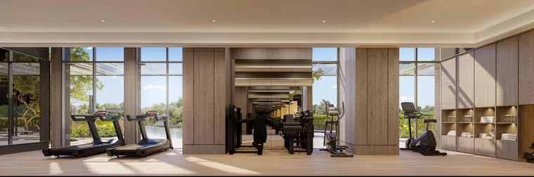 The Serra Residences fitness room with treadmills and weights overlooking greenery